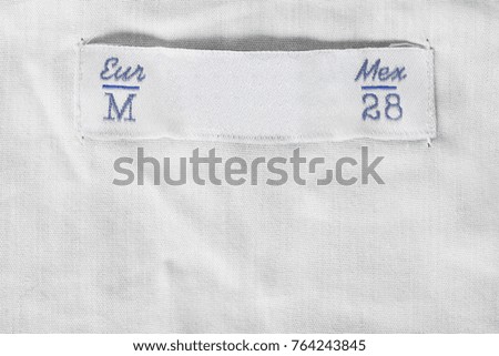 Medium size textile clothes label on white blank linen background