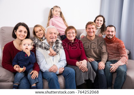 Friendly large family making numerous photos during family dinner. Focus on elderly man