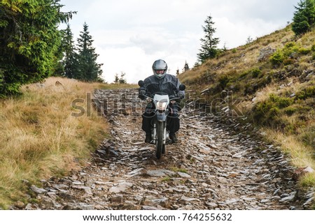 Motorcyclist on a mountainous road, Extreme sport, active lifestyle, adventure touring concept. High mountains, dirt roads. enduro off road touring
