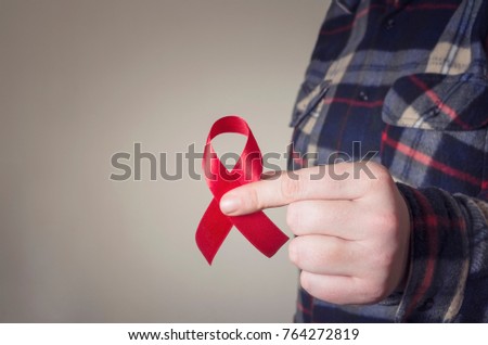 Aids Awareness. Male hands holding the red AIDS awareness ribbon. Healthcare and medicine concept.