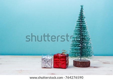 Little green handmade gift boxes in a snow covered miniature evergreen forest