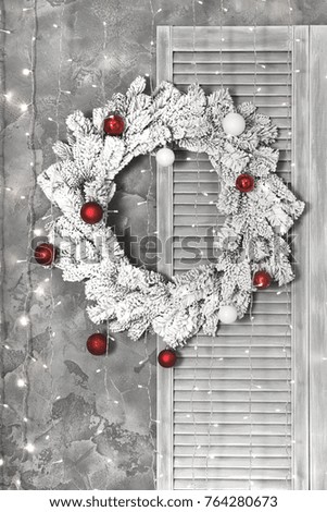 Christmas snow covered wreath on wall with lights