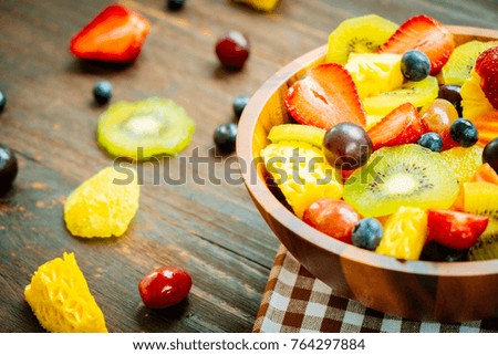 Mixed and assorted fruits with kiwi strawberry grape and other in bowl on wood table - Filter Processing