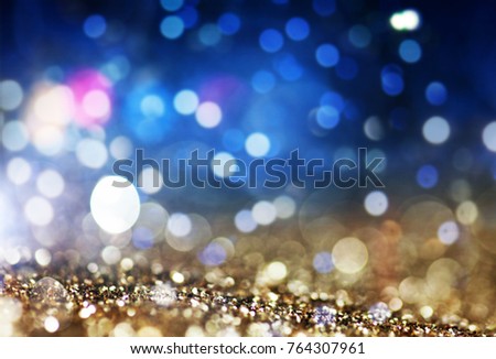 holiday abstract glitter background with blinking stars and falling snowflakes. Blurred bokeh of Christmas lights.