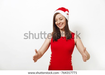 Pretty caucasian happy woman wearing red dress and Christmas hat holding copy space between palms for advertisement or text on white background. Santa girl isolated. New Year holiday 2018 concept.