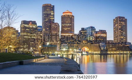 The mix of contemporary and historic architecture of Boston in Massachusetts, USA at night showcasing the Boston Harbor and Financial District.