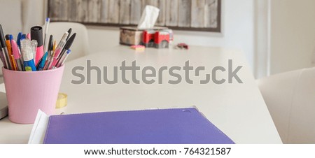 Office. Container with pens and a folder on a table 