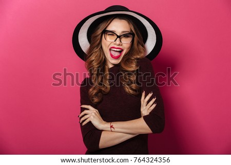 Image of young pretty lady wearing hat standing isolated over pink background. Looking camera.