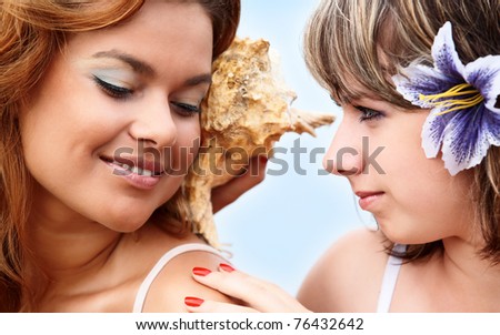 girls listening to the Sea sounds in the shell