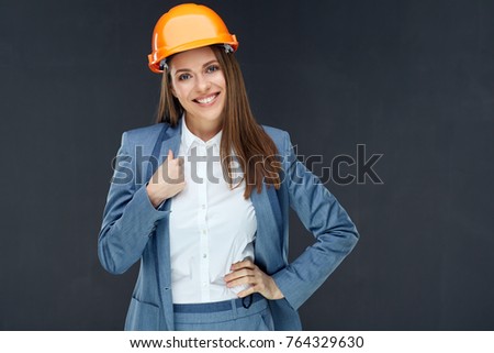 Smiling woman builder engineer business portrait on black. Business suit.