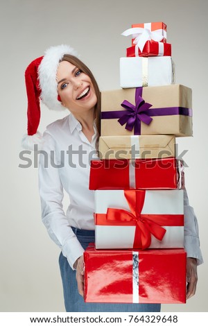 Young businesswoman holding pile, heap, stack of christmas gifts. 