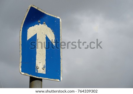 one way sign well used on a cloudy day