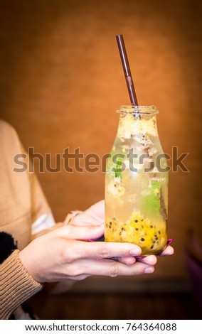 Summer Muddle with apple, passion fruit,banana a touch of green and top with soda water , Beverage cocktail isolated on brown background, Fresh strawberry and ice with sliced lemon in glass isolated.