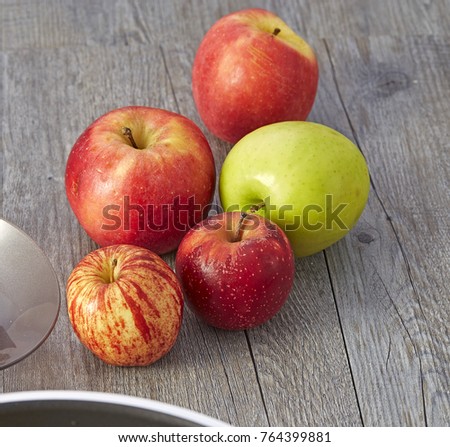 Multi-colored apples on wooden table.