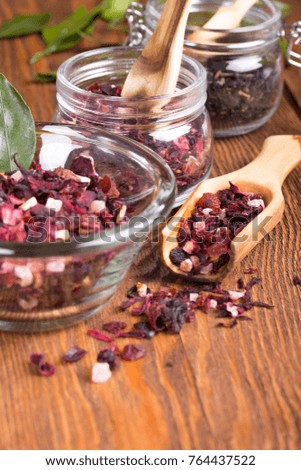 Herbal aroma fruit tea dry leaves on spoon on wooden background