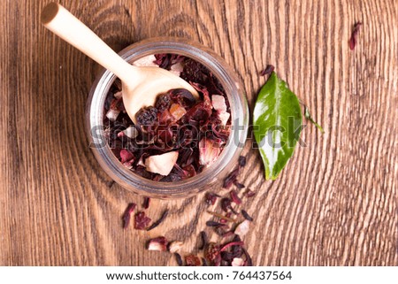 Herbal aroma fruit tea dry leaves on spoon on wooden background