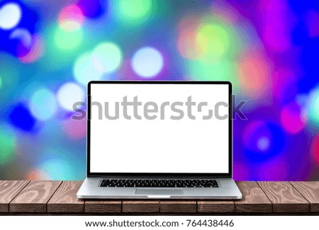 Modern laptop with empty white screen on wooden table against blurred Christmas lights background