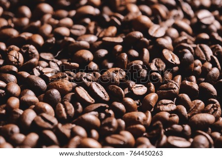 Top view of a coffee texture on a wooden background.Fresh quality coffee beans still hot and steaming. Concept of: relaxation, aroma and perfumes, brazilian and italian