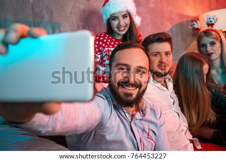Friends making selfie while celebrating Christmas or New Year eve at home