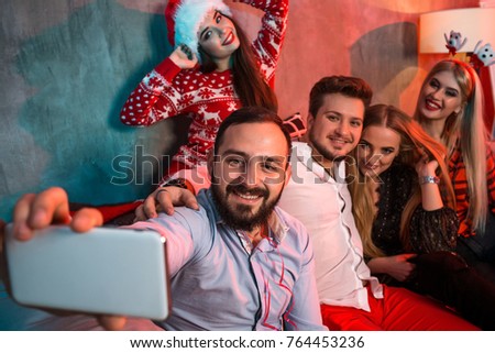 Friends making selfie while celebrating Christmas or New Year eve at home