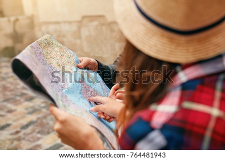Traveling Using Map. Female Holding Map In Hands. Close Up Of Couple Of Tourists Looking For Destination Location On Paper City Map, Pointing At Places. View Of Hands. High Quality Image.