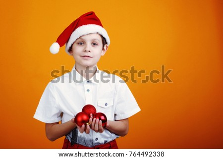 Cute little boy in a cap Santa Claus on a yellow background. Copyspace