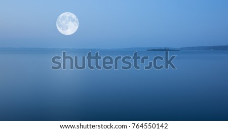 Minimalistic evening landscape with moon rising over the lake