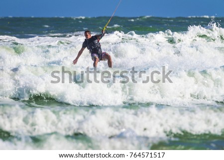 Young atletic man riding kite surf on a sea in Vietnam