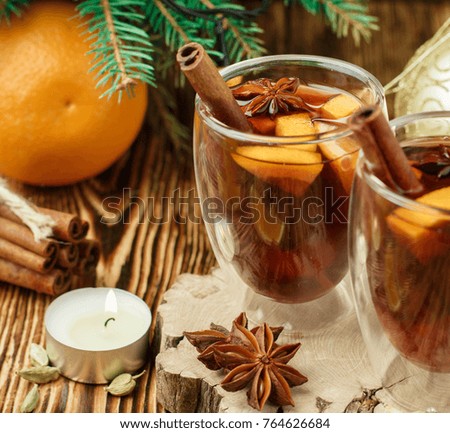 Mulled wine - Christmas hot drink with orange, cinnamon, cardamom and anise in a glass cups. New year. Selective focus. Square picture