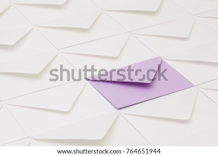 Composition with white envelopes and one purple envelope on the table.