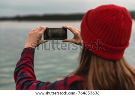 Beautiful woman enjoying her day taking pictures with her phone