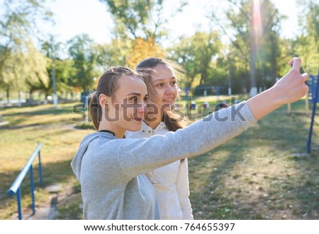 Beautiful girls taking a selfie with a smart phone.