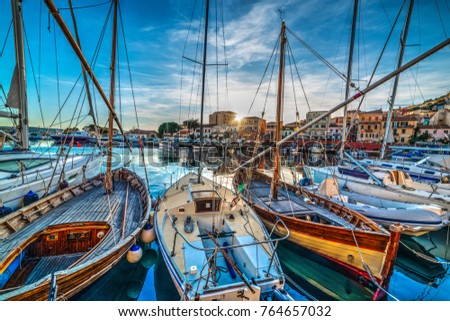 Wooden boats in La Maddalena harbor at sunset. Sardinia, Italy Royalty-Free Stock Photo #764657032
