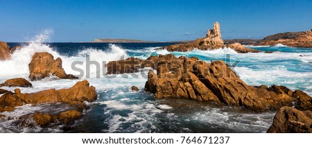 Waves break on the rocks at Cala Pregonda, Menorca Royalty-Free Stock Photo #764671237