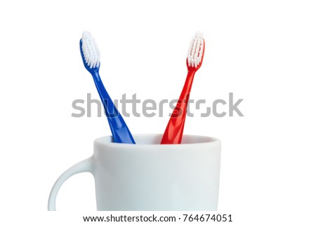 Close-up of Red and Blue Plastic Toothbrushes in White Mug Isolated on White Background Concept Dental Royalty-Free Stock Photo #764674051