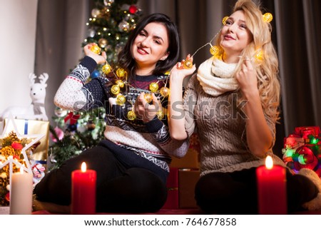 Happiness and friendship. Two women in christmas eve having fun in decorated house