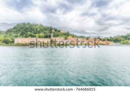 Defocused background with scenic view at dusk with waterfront of Bellagio town on the Lake Como, Italy. Intentionally blurred post production for bokeh effect