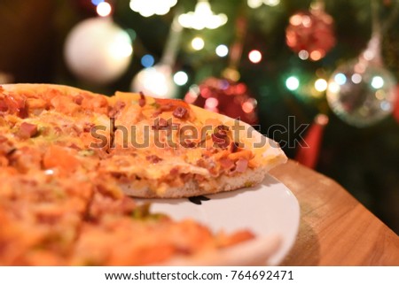 Pizza on the table in New Year's Eve. Mixture pizza Italian food. Delicious pizza served on wooden table, in the background lights and Christmas tree
