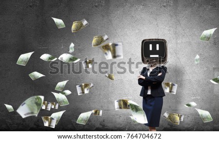 Business woman in suit with old TV instead of head keeping arms crossed while standing among flying euros and with gray dark wall on background.