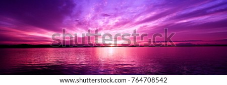 Delightful inspirational magenta coloured cloudy sea water tropical panoramic sunrise seascape featuring wispy cirrus clouds with sparkling ocean water reflections. Australia.