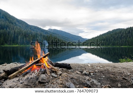 Landscape of a campfire in a peaceful lake valley. Royalty-Free Stock Photo #764709073