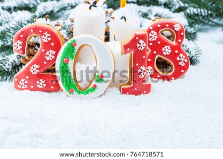 Christmas background with gingerbread cookie 2018, candle, snow and branches of a Christmas tree. Free space