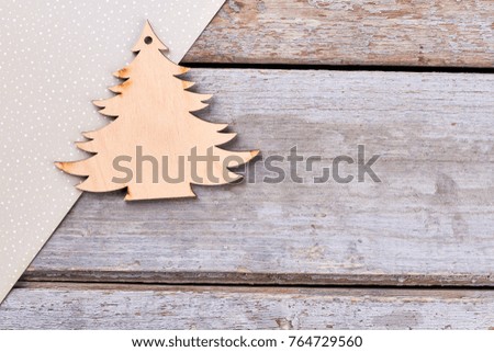 Carved wooden Christmas tree. Handmade wooden pendant Christmas tree, craft dotted paper on rustic wooden background, copy space.