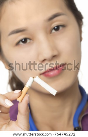 Asian doctor or nurse holding a broken cigarette to illuminate the concept of Quit Smoking isolated on a white background