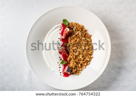 Granola with fruits and yogurt on white table background isolate. Flat top view, overhead.