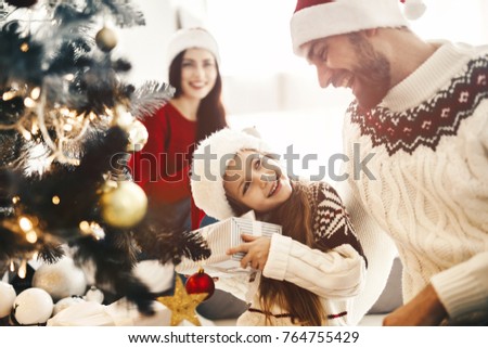 Christmas morning celebration, Mom and dad give present box container to their daughter, Enjoing Holidays Family people