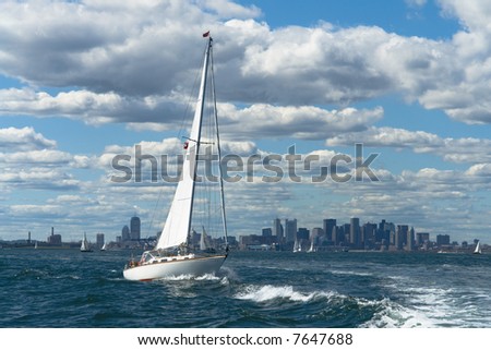 A sailboat crosses wake in front of Boston