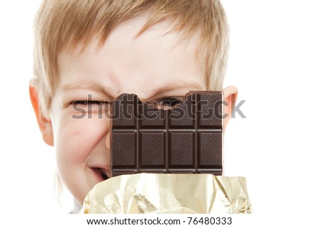 smiling boy looking through bar of chocolate