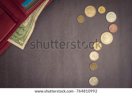 A question made up of coins, a purse with a dollar. Cash settlement, credit payment. Where is the money spent? Top view, vignetting.