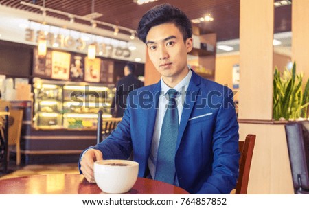 An Asian man who drinks coffee in a coffee shop